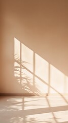 Sunlight streaming through a window, casting shadows of the window frame and a plant onto a beige wall and wooden floor in an empty room, creating a peaceful and minimalist atmosphere