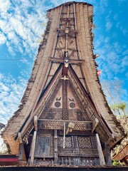 Traditional Tongkonan houses under a blue sky in Toraja, Sulawesi, Indonesia. Unique cultural architecture reflecting Torajan heritage