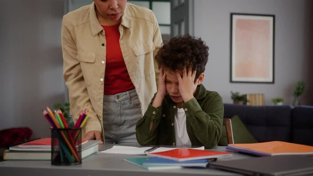 African American family at home little child kid boy studying learning woman girl female mother coming room check homework angry talking argument scolding son crying conflict education problem yell