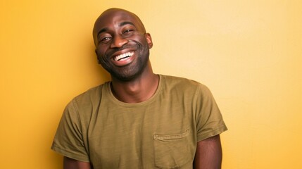 Obraz premium Smiling Black Man in Olive Green Shirt Posing Against Yellow Wall for Commercial Lifestyle Photography 