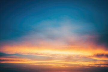 Fototapeta premium Vibrant sunset sky with orange, yellow, and blue hues, creating a breathtaking panorama.
