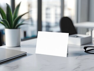 Blank card on office desk, near laptop and glasses, modern workspace, for marketing.