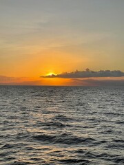 Sunrise over the ocean with Bali's Mount Batur in the distance. Captivating natural beauty and serenity.