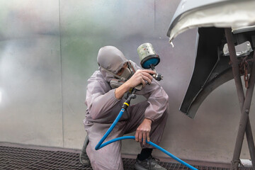 Auto Technician Spray Painting Car Bumper Edge