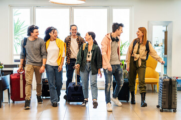 Young group of tourists with suitcases arriving at youth hostel guest house - Happy friends enjoying summer vacation together - Millenial people doing check-in at hotel lobby - Summertime holidays