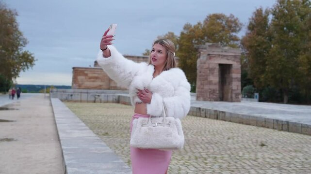 Influencer taking selfie in front of temple of debod, madrid