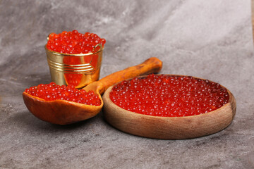 plates and bowls with red caviar on a light background