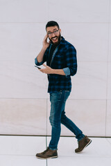 Pedestrian guy happily listening to music on smartphone