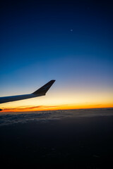 on a plane looking over the wing at sunset