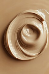 Creamy beige substance swirled in a circular motion, showcasing smooth texture and rich color variations in a minimalistic composition