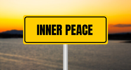Inner peace message written on yellow sign with blurry lake background. Conceptual inner peace symbol. Copy space.