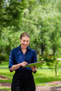 female speech pathologist holding phonics resources outside