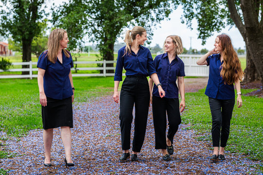 team of happy smiling businesswomen in group talking together outdoors