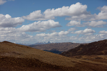 Stunning view of rolling hills and distant mountains under a vibrant sky in Scotland during springtime