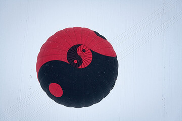 A black and red hot air balloon with a yin yang symbol on it