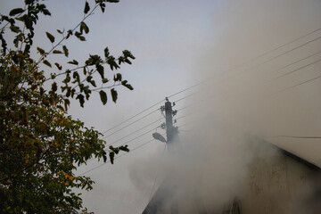 Smoke billows from a structure as emergency responders work to control the fire in a densely...