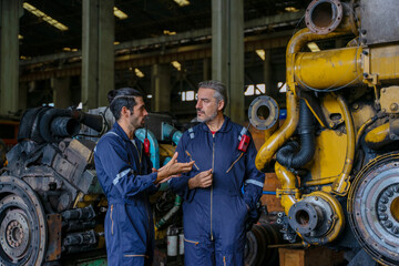 Technicians work at train engine repair shop.