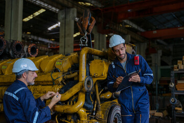 Technicians work at train engine repair shop.