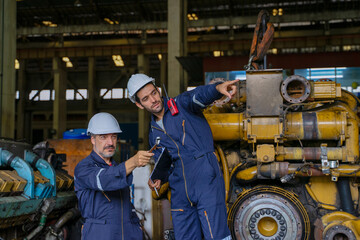 Technicians work at train engine repair shop.