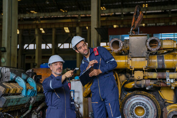 Technicians work at train engine repair shop.