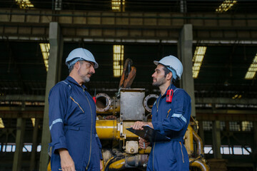 Technicians work at train engine repair shop.