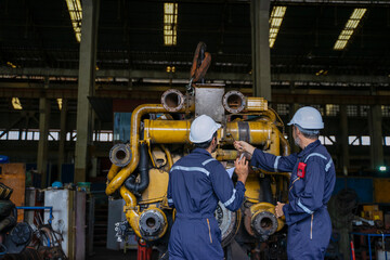 Technicians work at train engine repair shop.
