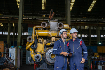 Technicians work at train engine repair shop.