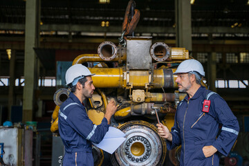 Technicians work at train engine repair shop.