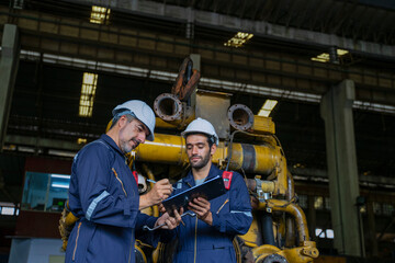 Technicians work at train engine repair shop.