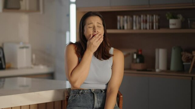 Lazy bored Caucasian woman yawning closing mouth hand yawn tired female at home. Boredom inactive lifestyle apathy fatigue

