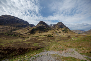 Majestic Scottish Highlands under a clear sky showcase rugged mountains and serene landscape in early afternoon light