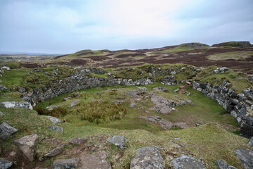 Exploring the ancient ruins on the Isle of Skye in Scotland amidst rolling green hills and dramatic skies