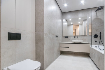 Stylish design of the bathroom, decorated with light gray tiles with black elements. .Mirror over the sink bowl.
