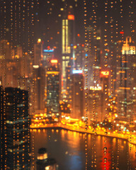 Fototapeta premium Rain-streaked window view of a glittering, vibrant cityscape at night. Perfect for illustrating urban mood, travel, or weather concepts.