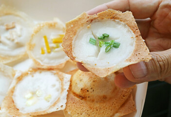 Hand Picking a Kanom Krok Spring Onion Topping, Thai coconut milk pancake which one of the popular street food in Thailand