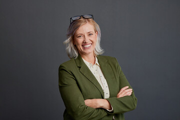 Portrait of confident mature woman isolated on gray wall