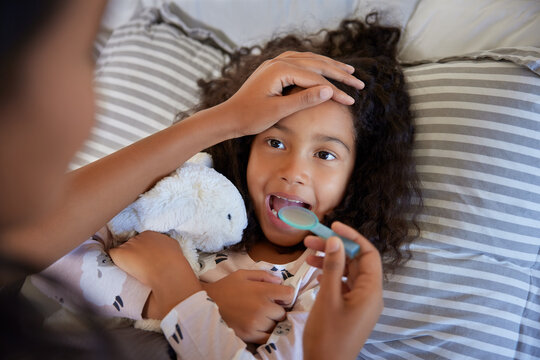 Loving mother giving medicine to her little girl