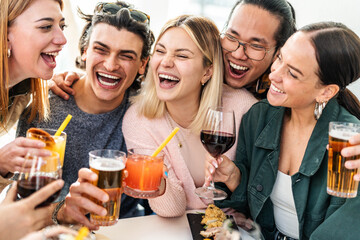 Multiracial friends celebrating party drinking cocktails at bar restaurant - Young people having...