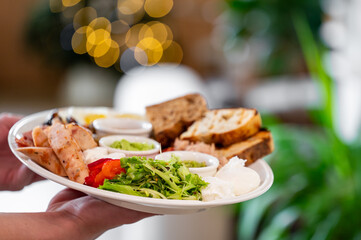 A beautifully arranged plate featuring sausages, poached eggs, fresh salad, and toasted bread, set against a blurred background with warm bokeh lights. Perfect for food-related themes.