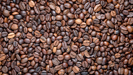 Close up flat lay view of brown roasted coffee beans with fine details background backdrop wallpaper