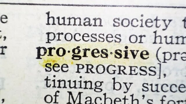 A man marks the definition from the word progressive on a printed page with a marker pen