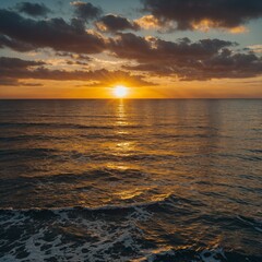 Obraz premium Sunset over the ocean with shimmering golden reflections.