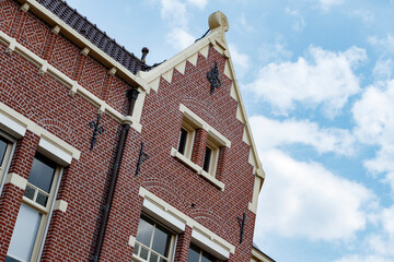 Red brick architecture featuring intricate designs against a clear blue sky near a historic district