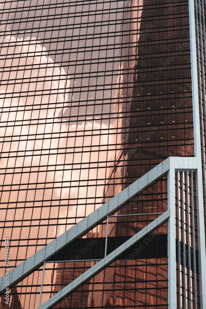 Poster A large glass building with a reflection of a cloud in the windows. The building is very tall and has many windows, giving it a modern and sleek appearance