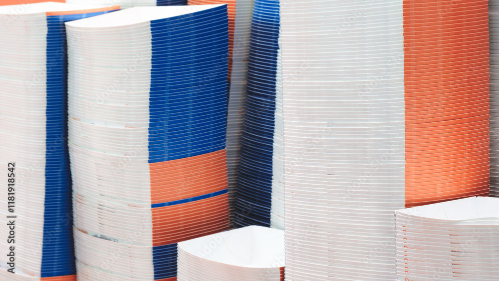 Aufkleber a stack of paper plates with blue and orange stripes. the plates are piled high and are of different