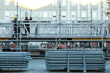 Builders erect a stage for a concert on a square in a European city