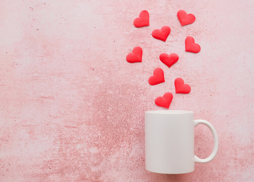 White mug mockup with heart shape confetti on pink background
