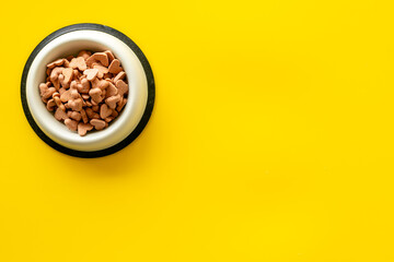 Bowl of biscuits for pets - food in a shape of heart, top view