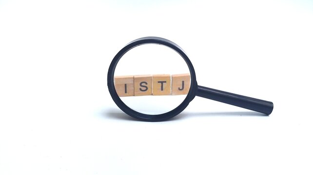 Wooden blocks with ISTJ letters, through a magnifying glass. ISTJ is one of the 16 personality types identified by the Myers-Briggs Type Indicator or MBTI. Concept of psychology.