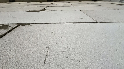 A white tiled floor with a few cracks in it. The cracks are small and not very noticeable